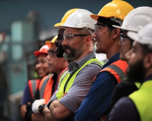 a man wearing a hat standing in front of a crowd