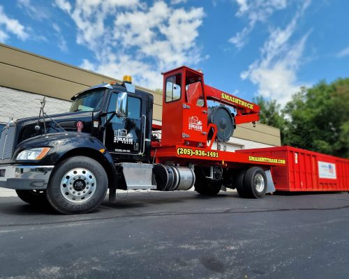 A Smash Truck® from Smash My Trash® getting ready to perform mobile waste compaction on an open-top dumpster.