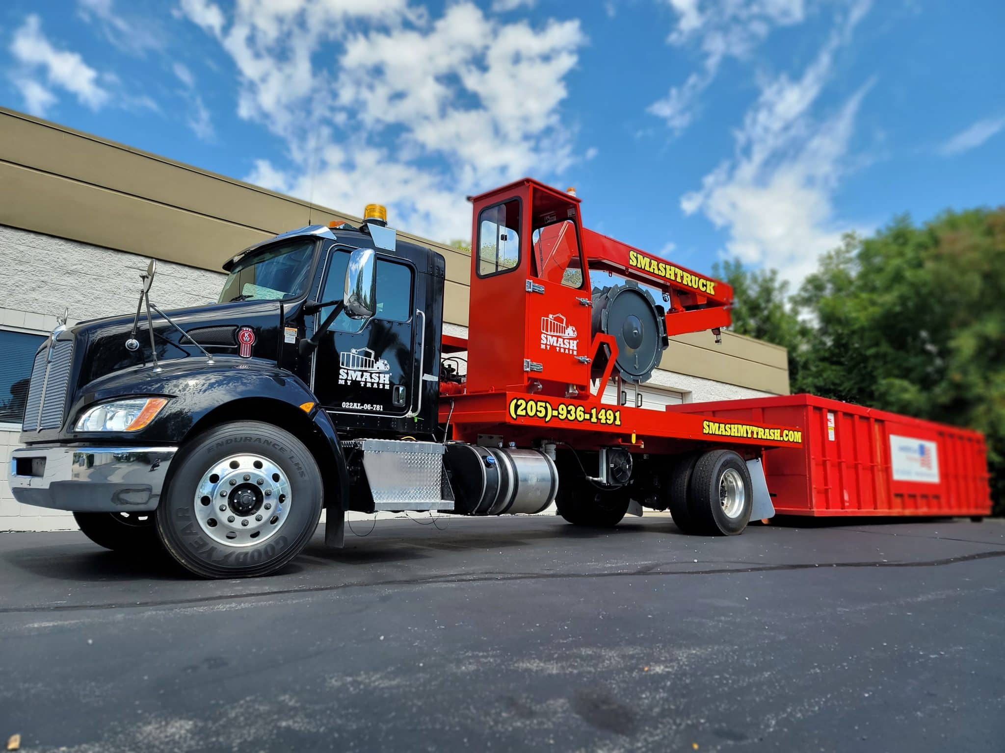 A Smash Truck® from Smash My Trash® getting ready to perform mobile waste compaction on an open-top dumpster.