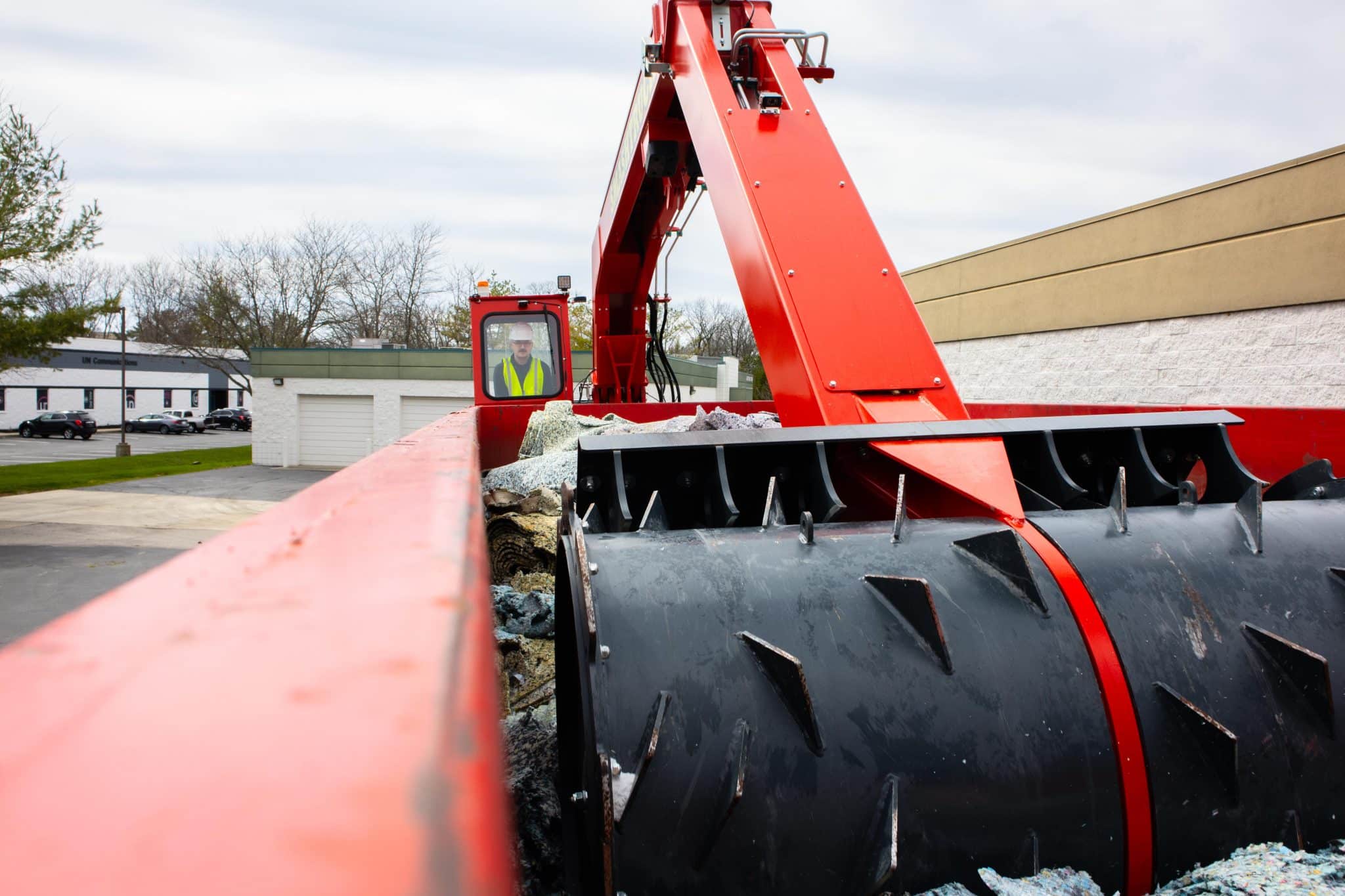 A Smash Truck® operator performing mobile waste compaction on an open-top roll-off dumpster.