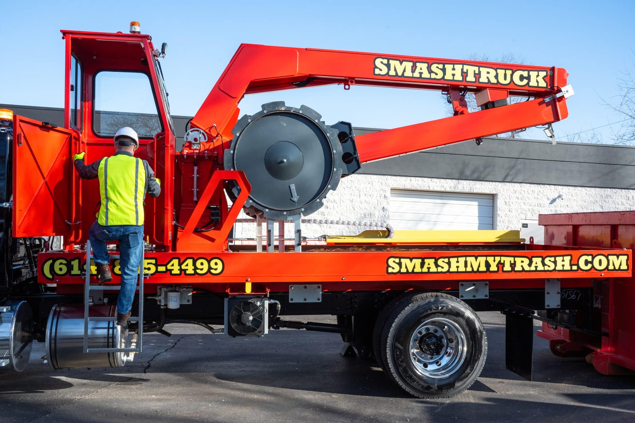 A Smash Truck from Smash My Trash getting ready to perform mobile waste compaction before the dumpster is hauled.