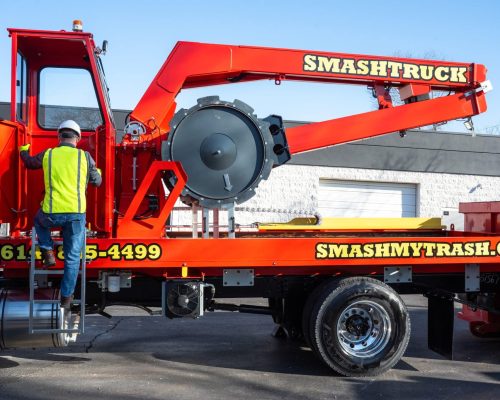 A Smash Truck® operator from Smash My Trash® preparing to perform mobile waste compaction on an open-top dumpster.
