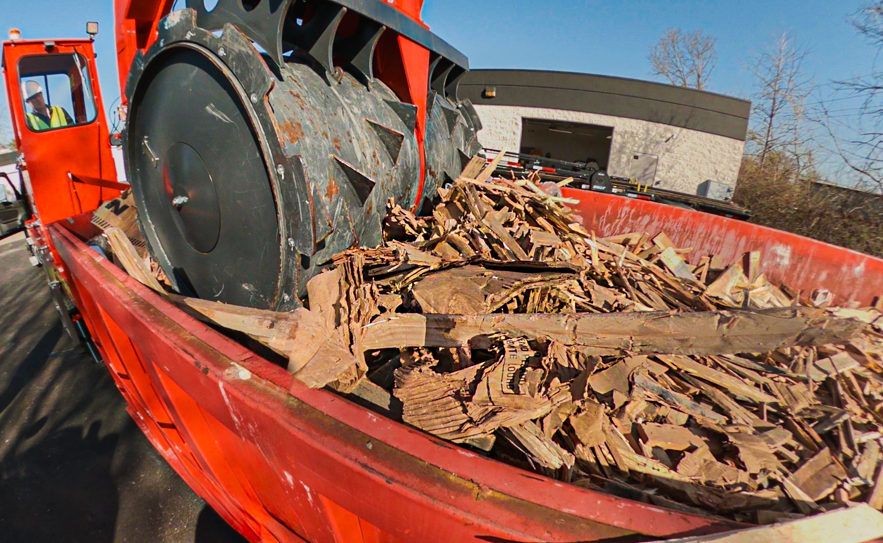 A Smash Truck® breaking up pallets in an open-top roll-off dumpster during mobile waste compaction service.